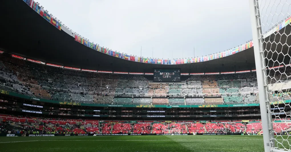 Vista externa do Estádio Azteca com iluminação e público durante evento
