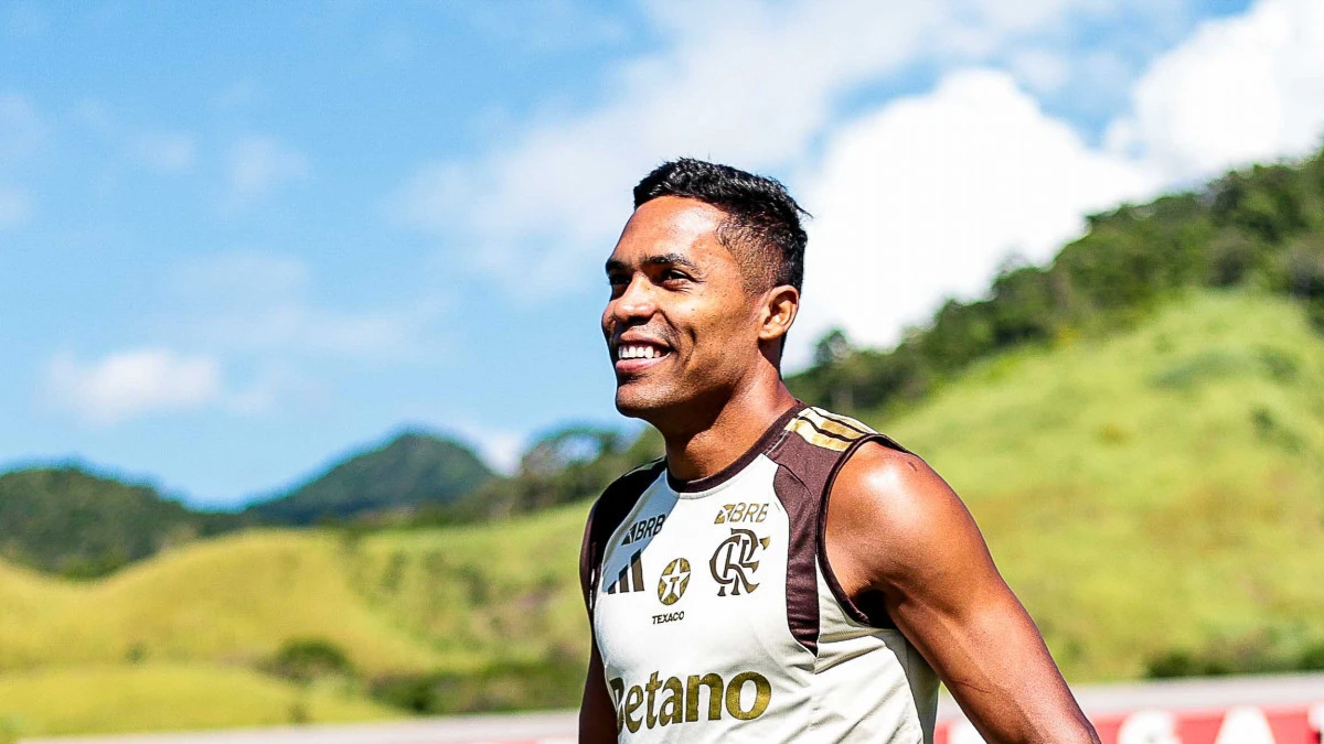 Alex Sandro durante treino do Flamengo com bola e companheiros ao fundo