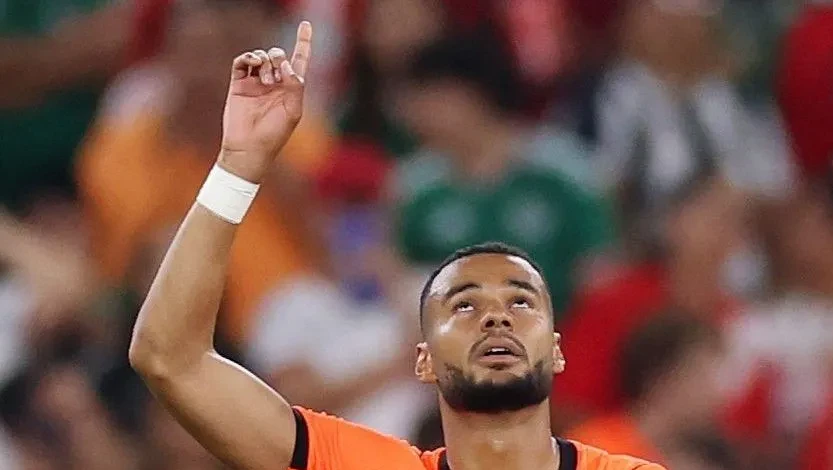 Cody Gakpo emocionado cobrindo o rosto após marcar gol pela seleção