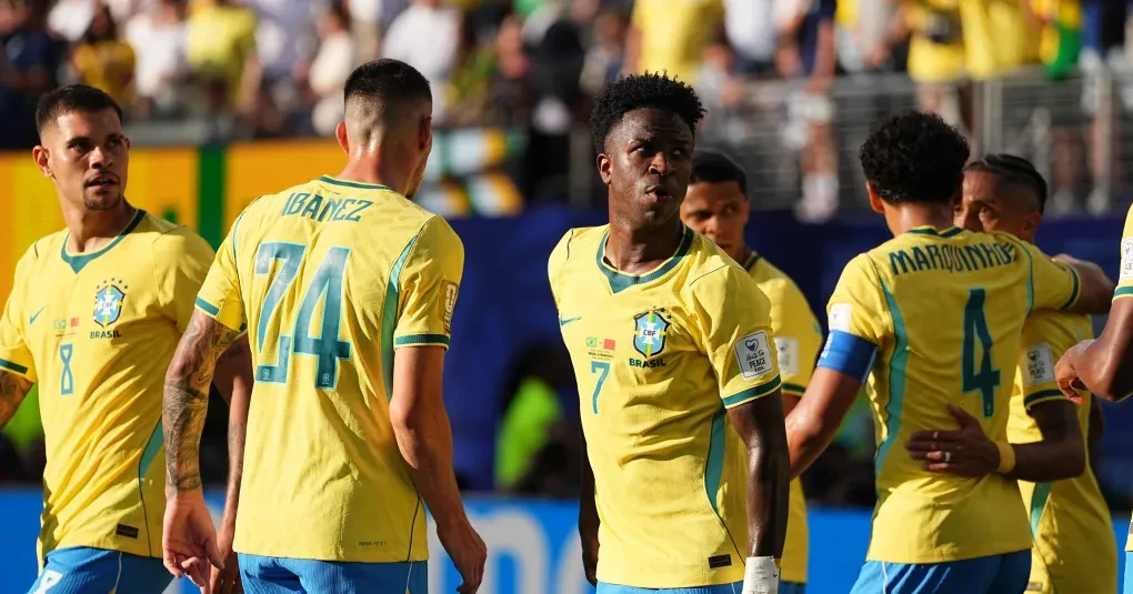 Torcida brasileira com bandeiras e camisas vibrando em estádio durante jogo da Seleção