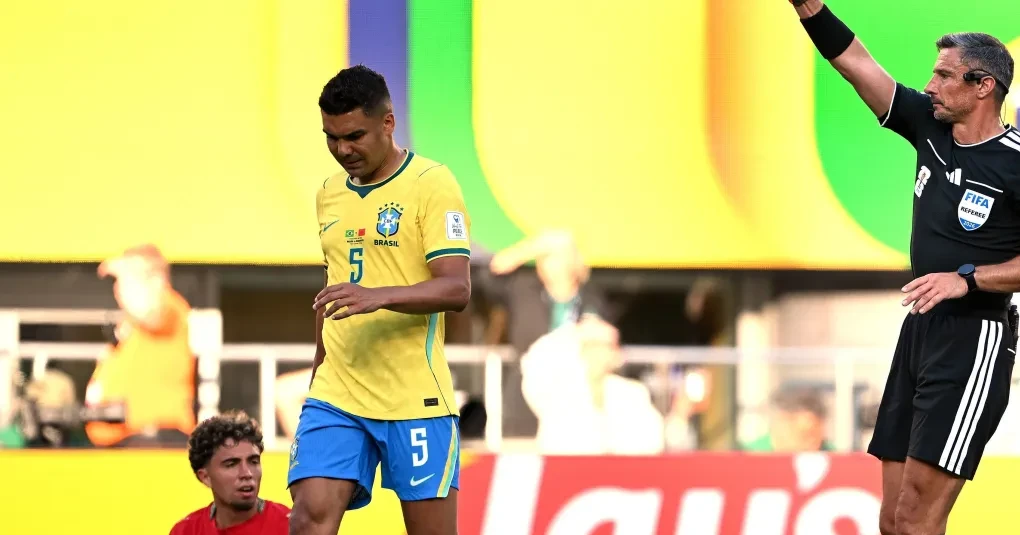 Seleção brasileira em campo durante partida, jogadores em ação próximos à linha de fundo