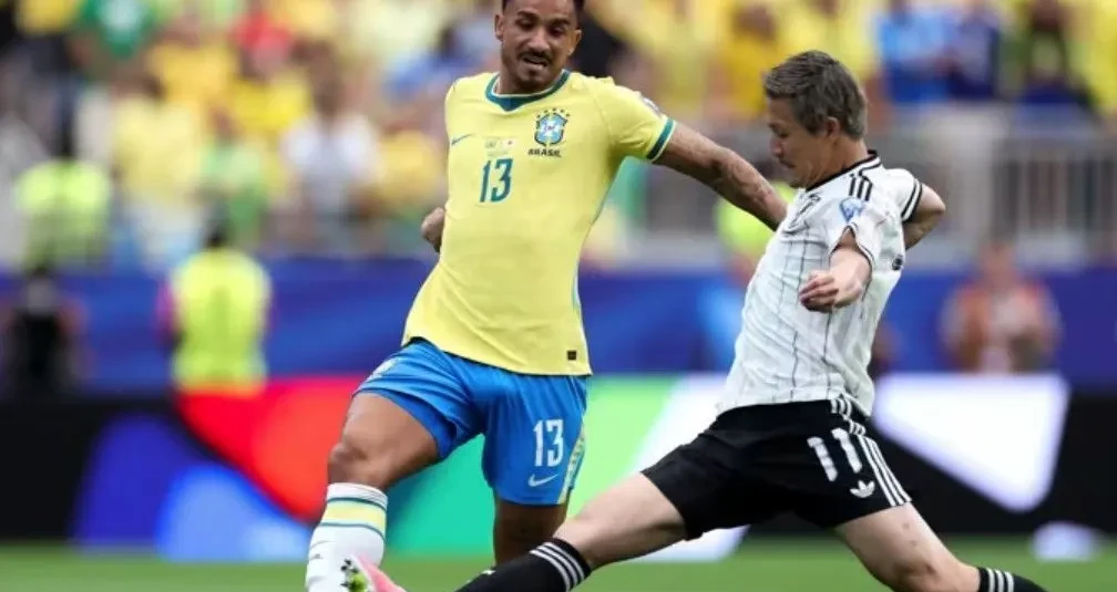 Torcida brasileira com bandeiras e camisas acompanhando partida em estádio