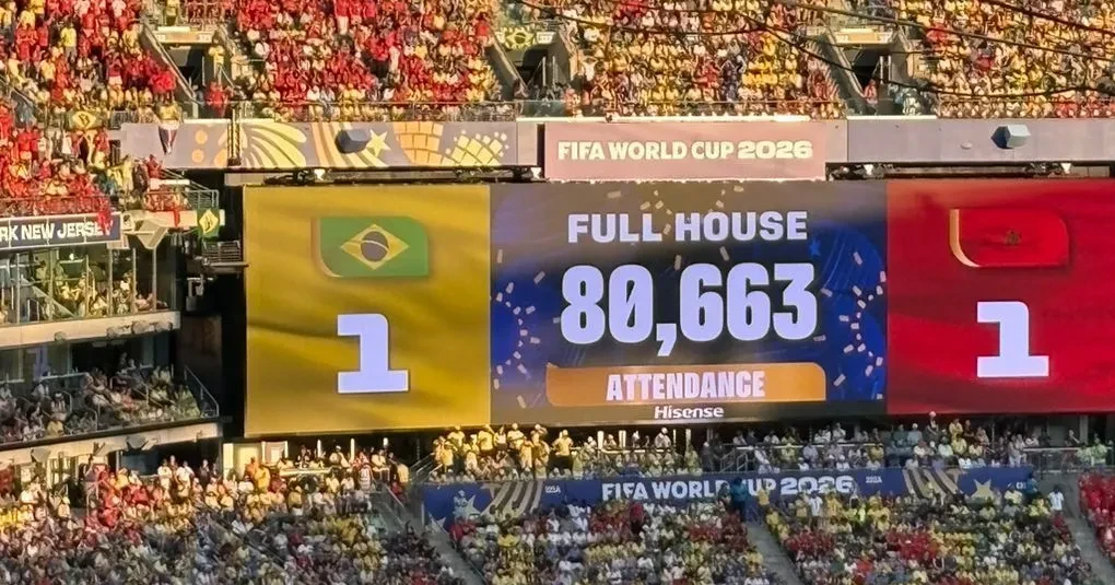 Torcida lotando o estádio durante Brasil x Marrocos com bandeiras e camisas das seleções