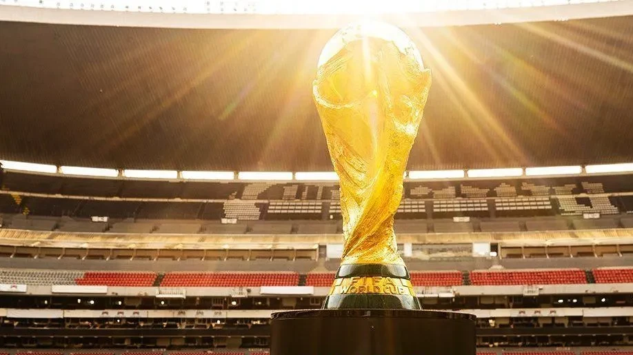Jogadores em campo sob sol intenso e calor, com termômetros marcando alta temperatura