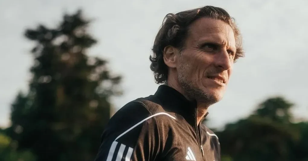 Diego Forlán em entrevista, expressão concentrada e microfone à frente