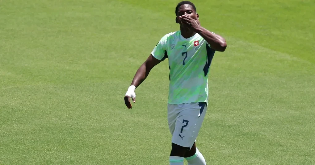 Breel Embolo comemorando um gol vestindo a camisa da seleção da Suíça