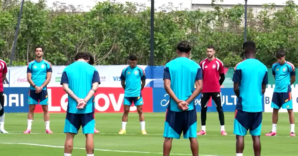 Jogadores espanhóis em fila respeitando minuto de silêncio no local de treino em Guadalajara