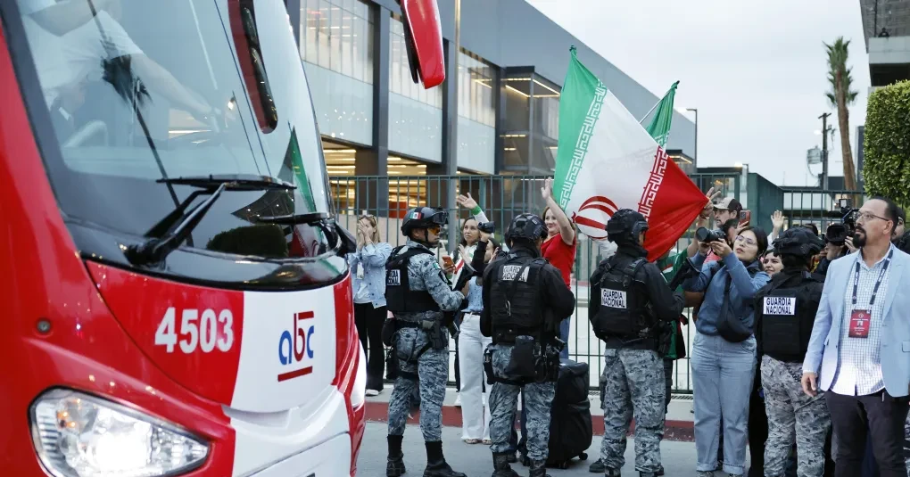 Torcedores iranianos segurando bandeiras no estádio antes de partida