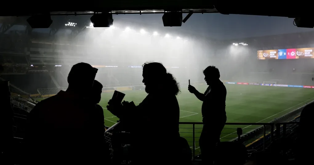 Telão do Lincoln Financial Field exibindo aviso de tempestade e torcedores nas arquibancadas