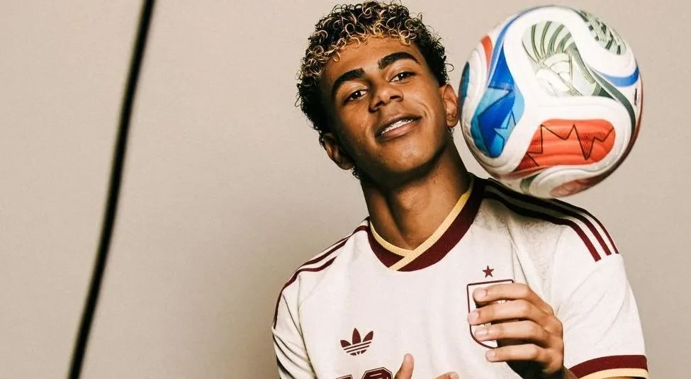 Lamine Yamal em entrevista vestindo a camisa da seleção espanhola, gesticulando