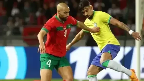 Torcedores com camisas do Brasil e bandeiras no estádio antes de partida internacional