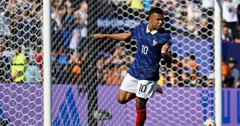 Kylian Mbappé comemorando gol com bandeira da França durante partida da Copa do Mundo