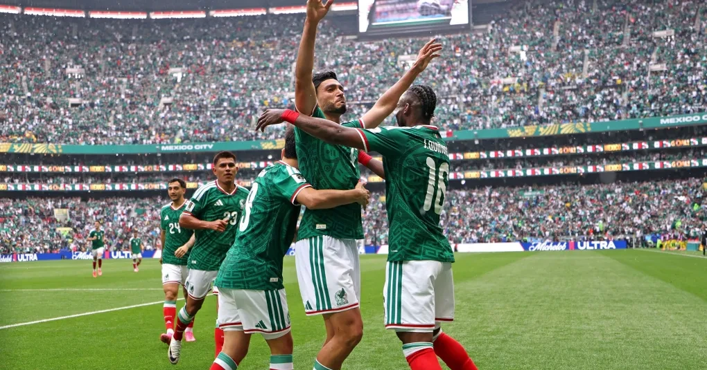 Raúl Jiménez com faixa protetora na cabeça vestindo a camisa da seleção do México em campo