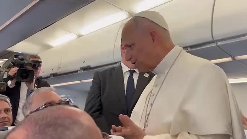 Papa Leão XIV falando com jornalistas a bordo de um avião durante viagem entre Roma e Madri