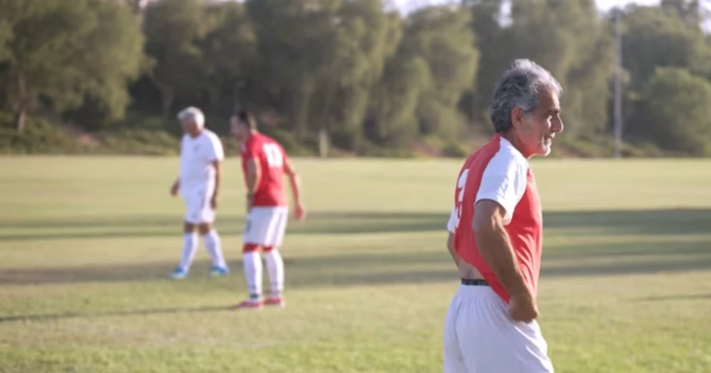Capitão Nader Adeli segurando a camisa do Arya Football Club com as cores da bandeira iraniana