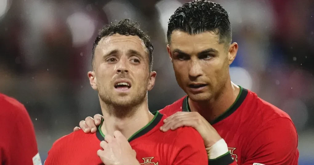 Torcedores portugueses exibindo faixas e pulseiras em homenagem a Diogo Jota antes de partida