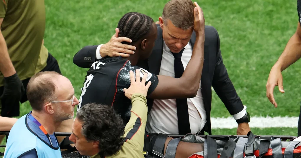 Ismaël Koné sendo atendido e retirado de maca no campo após lesão