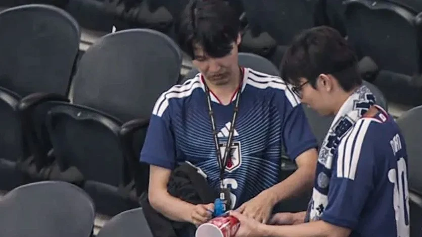 Torcedores japoneses recolhendo lixo nas arquibancadas do AT&T Stadium em Dallas