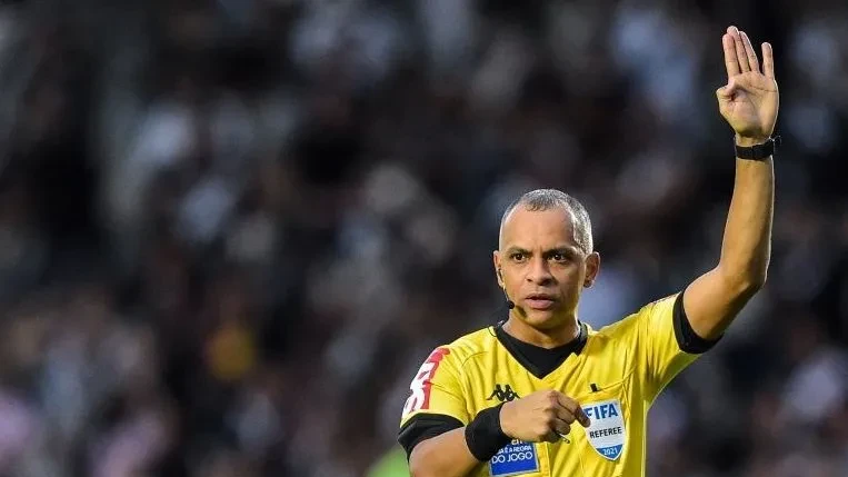 Wilton Pereira Sampaio com apito e uniforme de árbitro em campo