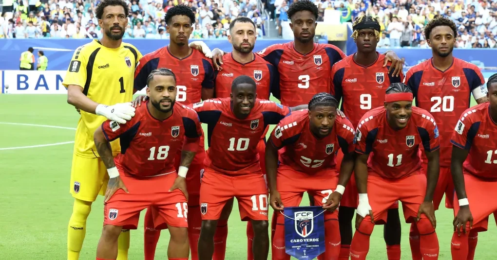 Jogadores de Cabo Verde comemorando uma jogada em campo com bandeira da seleção