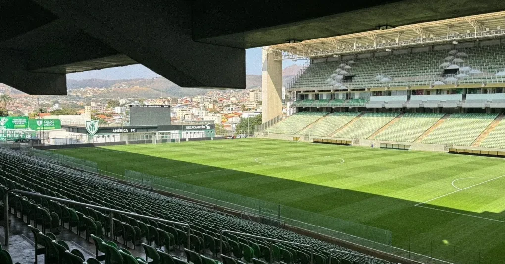 Jogadores do América-MG comemorando gol no Estádio Independência com torcida ao fundo