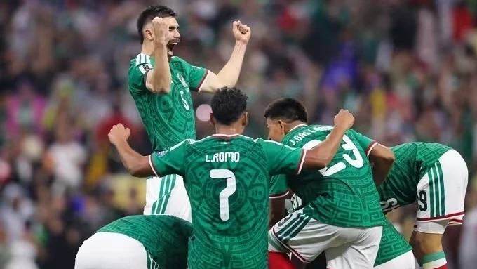Jogadores do México comemorando gol no Estádio Azteca com a torcida ao fundo