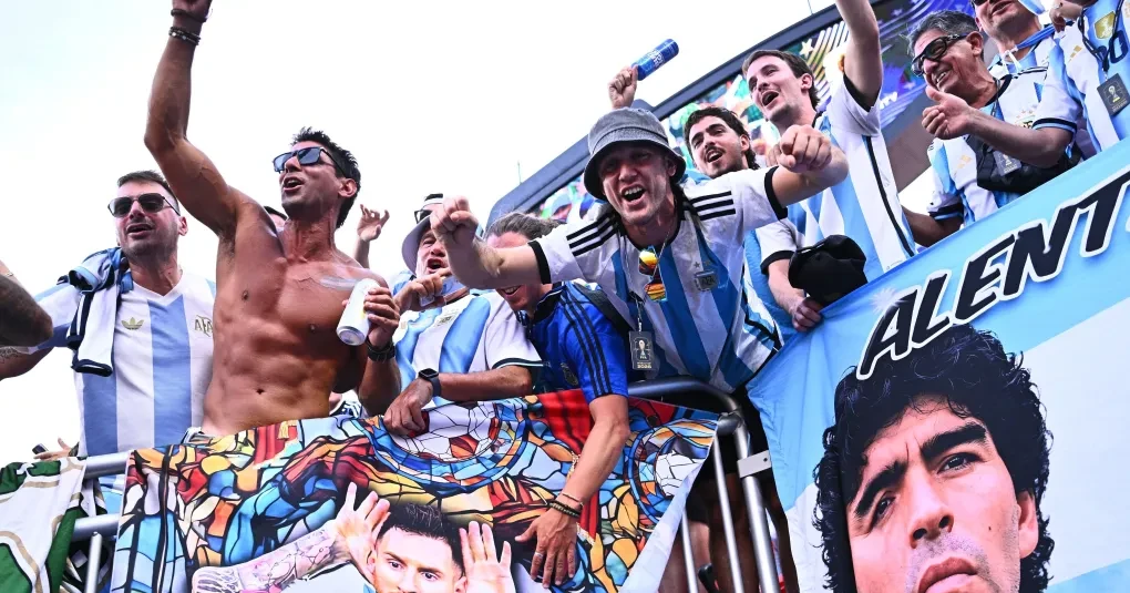 Torcedores argentinos com bandeiras em área externa do estádio