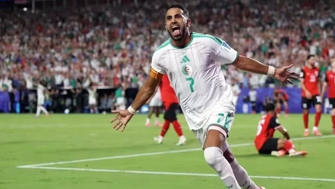 Riyad Mahrez comemorando com a camisa da seleção da Argélia em campo