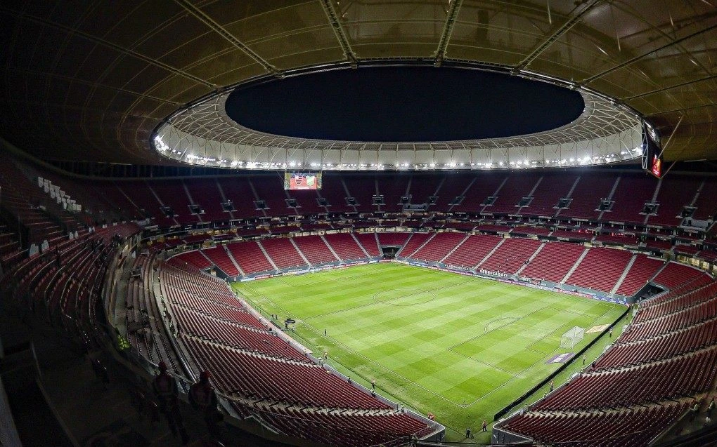 Visão externa do Estádio Mané Garrincha em Brasília, com iluminação noturna