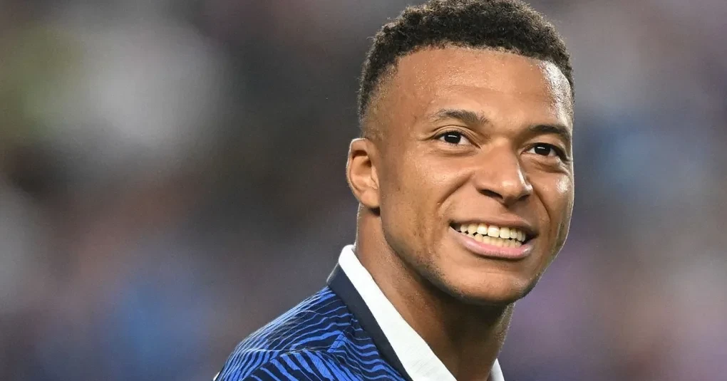 Kylian Mbappé em ação com a camisa da seleção francesa comemorando um gol