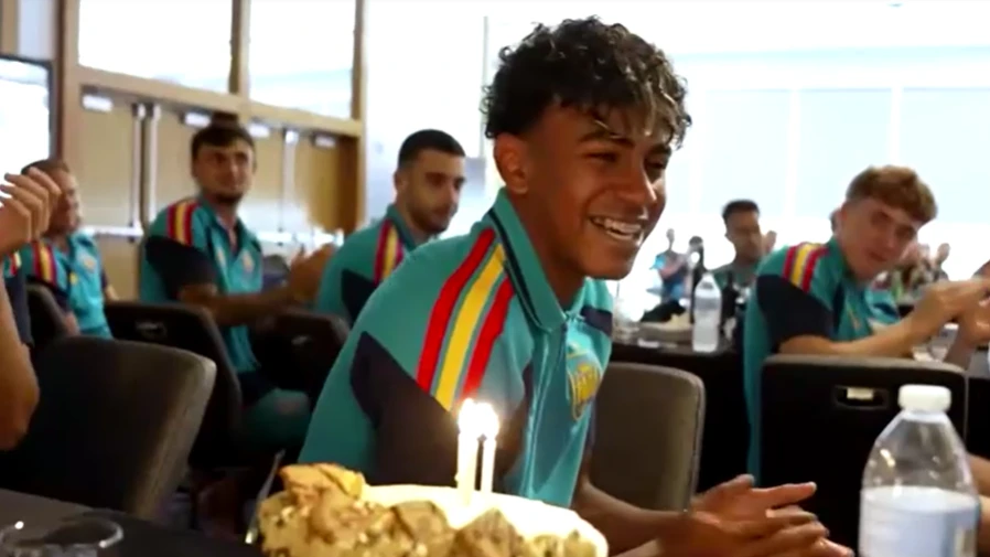 Lamine Yamal sorrindo ao lado de bolo de aniversário no centro de treinamentos da seleção espanhola