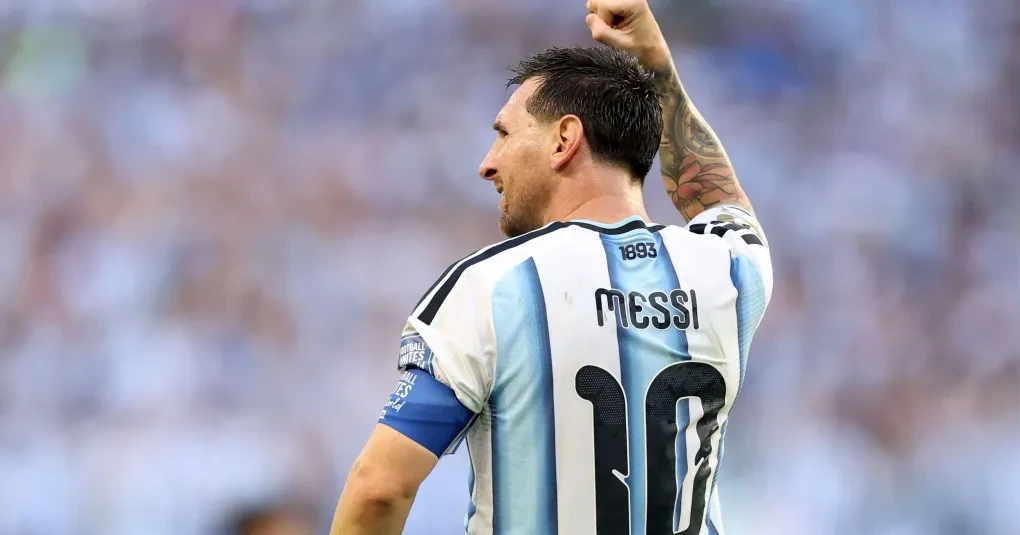 Lionel Messi celebrando durante partida da Argentina, com bola e companheiros ao fundo
