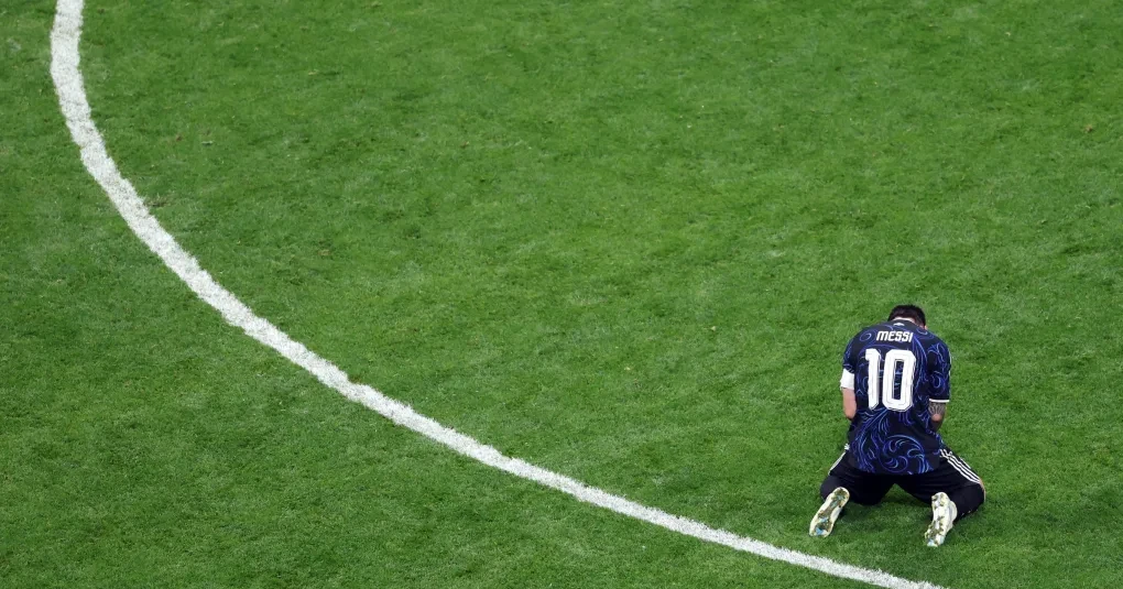 Lionel Messi ajoelhado e comemorando no gramado após classificação