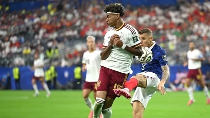 Jogadores em disputa de bola durante França x Espanha com público ao fundo
