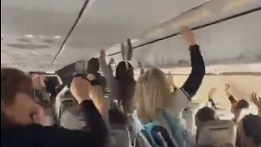 Passageiros dentro de avião comemorando o resultado de partida de futebol