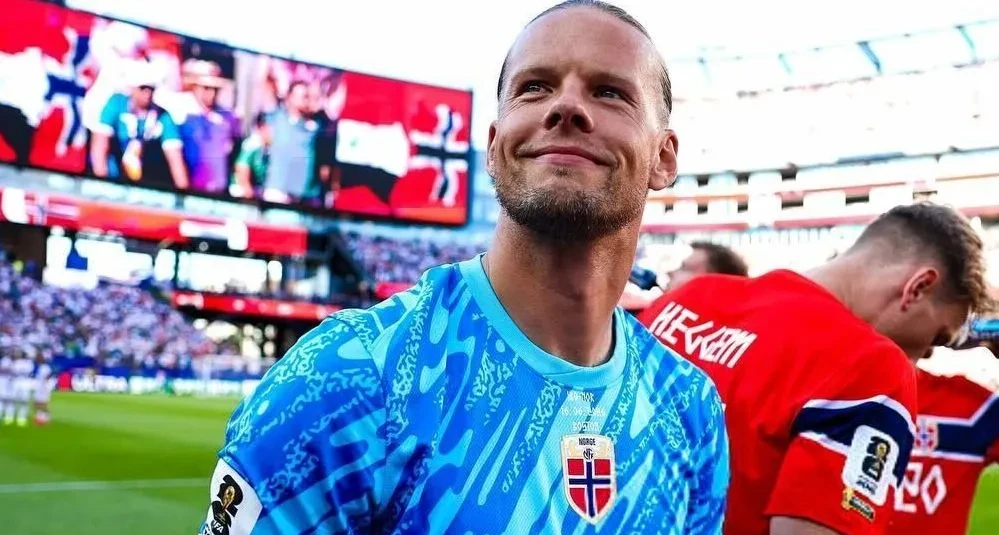 Orjen Nyland em chute defendido com as mãos, com as traves ao fundo