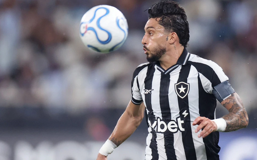 Alex Telles em disputa de bola com camisa do Botafogo
