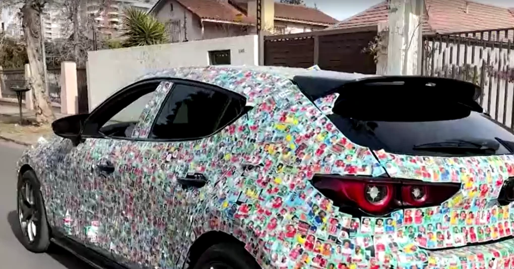 Mazda 3 totalmente coberto por adesivos de figurinhas da Panini, formando um álbum gigante