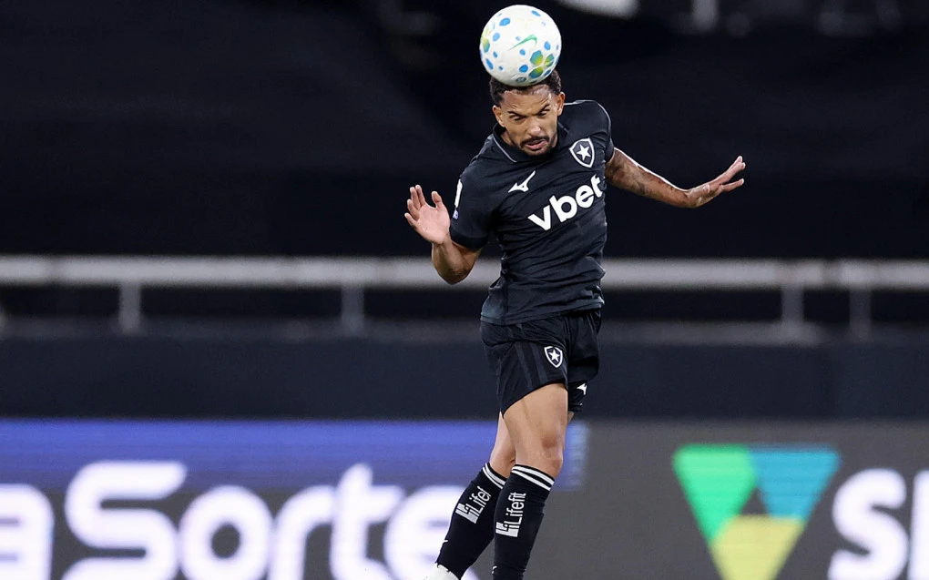 Vitinho com a bola dominada, camisa do Botafogo em ação no campo
