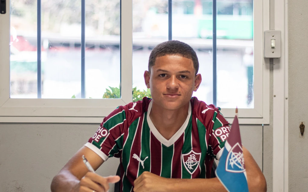 Lucas assinando contrato profissional com a camisa do Fluminense nas Laranjeiras