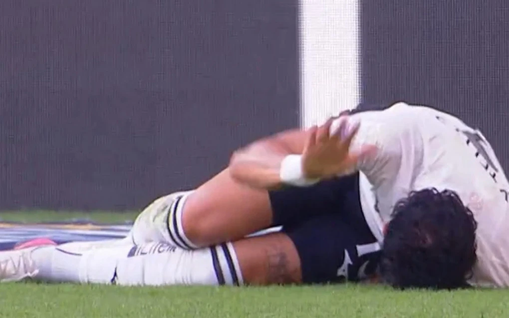 Alex Telles segurando a parte posterior da coxa no momento da reclamação de dor durante a partida
