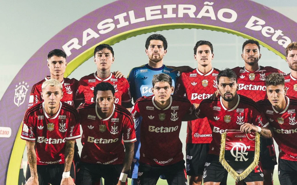 Jogadores do Flamengo comemoram gol com a torcida ao fundo