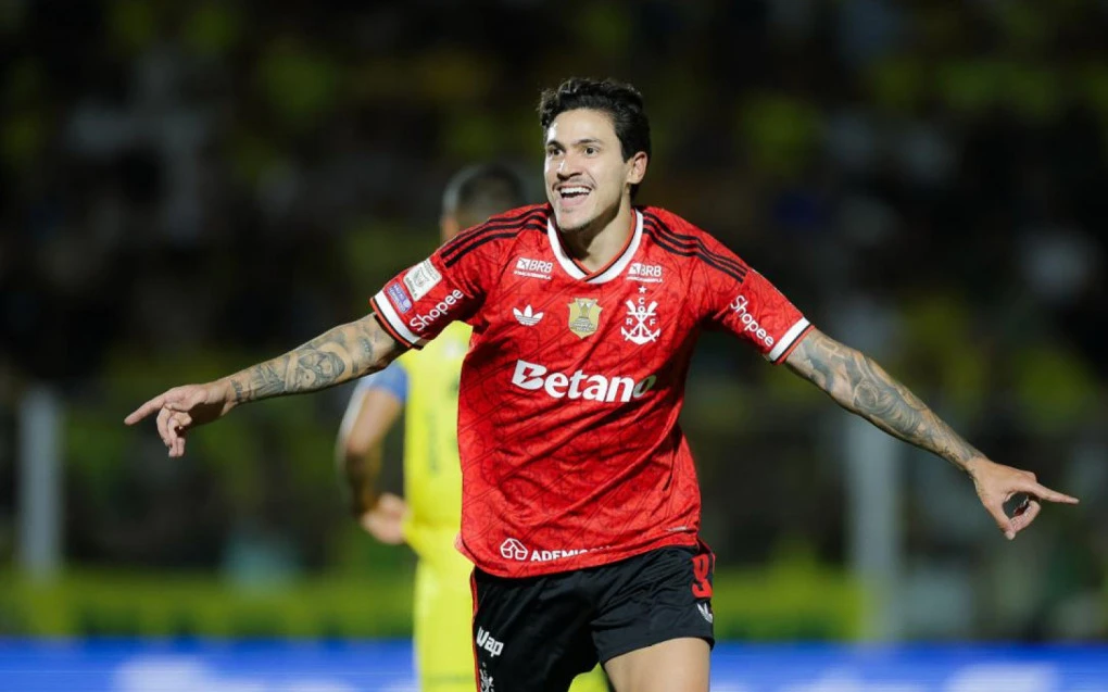Pedro comemorando gol pelo Flamengo com a torcida ao fundo