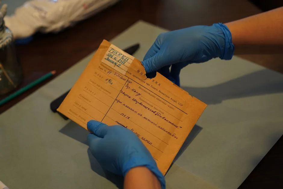 archivist handling old football newspapers