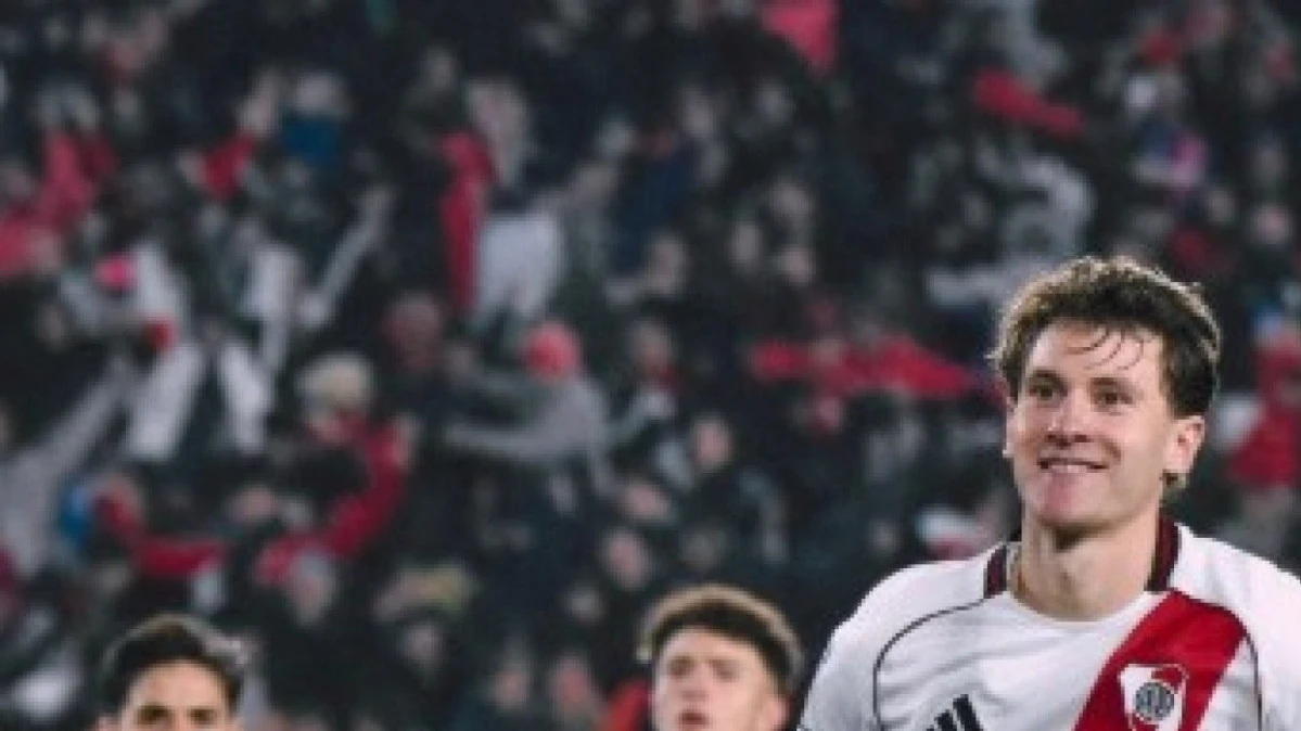 Facundo Colidio correndo e controlando a bola com a camisa do River Plate em partida