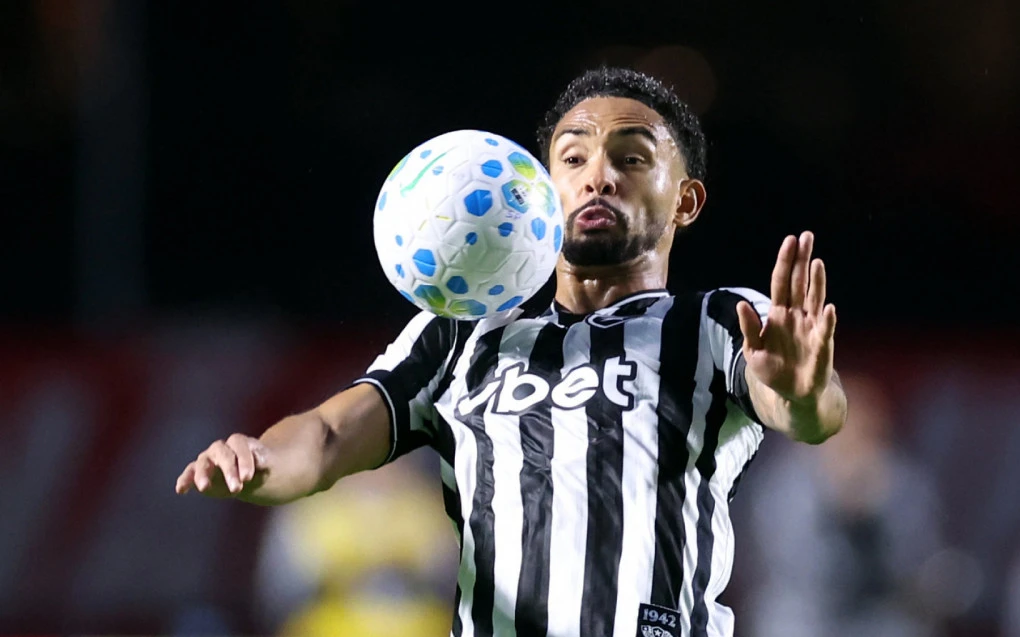 Vitinho disputando a bola vestindo o uniforme do Botafogo no Nilton Santos