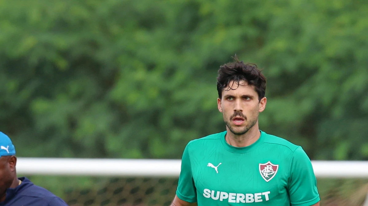 Igor Rabello com expressão de dor segurando o ombro, vestindo o uniforme do Fluminense