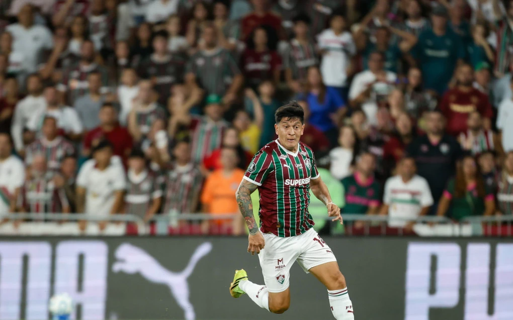 Germán Cano segurando a região da coxa durante a partida, semblante de dor