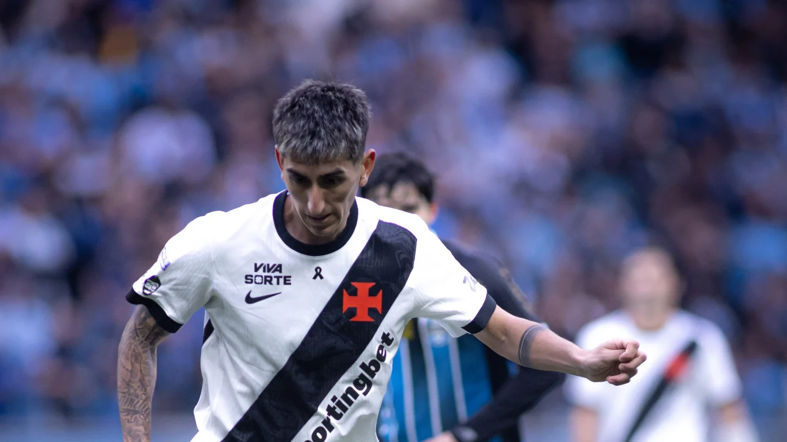 Lezcano disputando bola com defensor vestindo a camisa do Vasco em ação durante partida