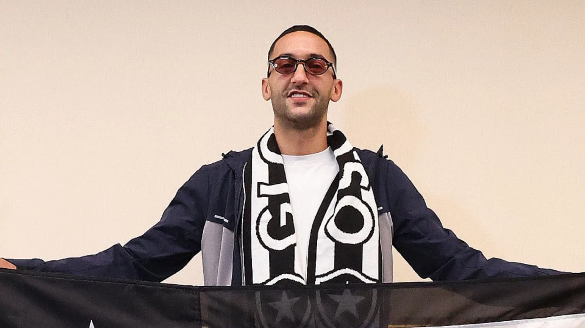 Hakim Ziyech segurando bandeira do Botafogo ao chegar ao Rio